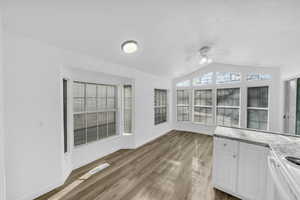 Unfurnished sunroom with vaulted ceiling and ceiling fan