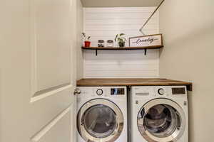 Laundry room with washer, dryer, and hanging rod