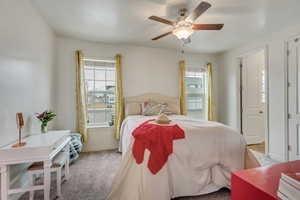 Carpeted primary bedroom featuring ceiling fan