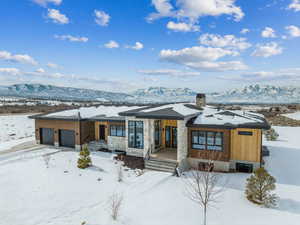 View of front of property featuring a garage, a chimney, and a mountain view