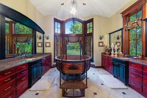 Bathroom featuring a healthy amount of sunlight, a washtub, and an inviting chandelier