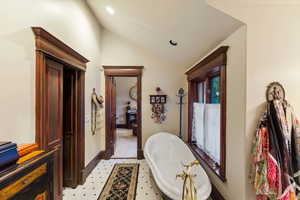 Bathroom with lofted ceiling and a bathing tub