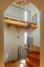 Staircase featuring a towering ceiling and beam ceiling