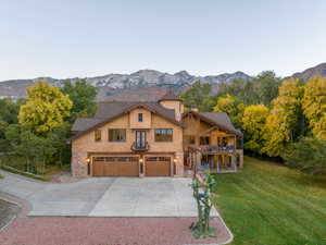 View of front of home with a garage, a mountain view, and a front lawn