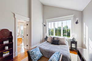 Bedroom with lofted ceiling and light hardwood / wood-style flooring