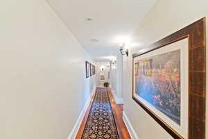 Hall with wood-type flooring and a textured ceiling