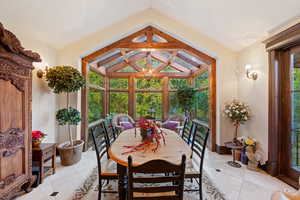 Sunroom / solarium with lofted ceiling and a notable chandelier