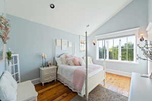 Bedroom with lofted ceiling and hardwood / wood-style flooring