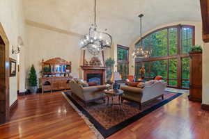 Living room featuring dark hardwood / wood-style flooring, a fireplace, and an inviting chandelier