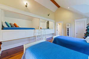 Bedroom with hardwood / wood-style floors and lofted ceiling with beams