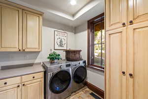 Laundry room featuring independent washer and dryer and cabinets