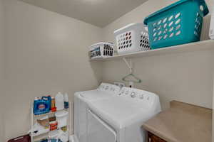 Clothes washing area with washer and dryer and a textured ceiling