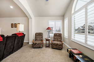 Living area featuring vaulted ceiling and carpet floors