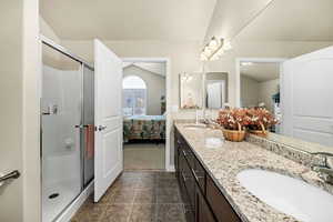 Bathroom featuring vanity, a shower with shower door, and tile patterned flooring