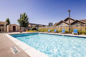 View of swimming pool with a storage unit and a patio