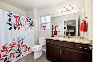 Bathroom featuring vanity, tile patterned floors, and toilet