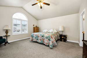 Bedroom featuring ceiling fan, lofted ceiling, and carpet flooring