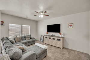 Living room with a textured ceiling and ceiling fan