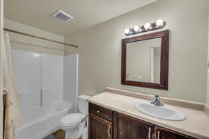 Full bathroom with toilet, vanity, tub / shower combination, and a textured ceiling