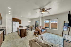 Living room featuring a textured ceiling, ceiling fan with notable chandelier, and sink