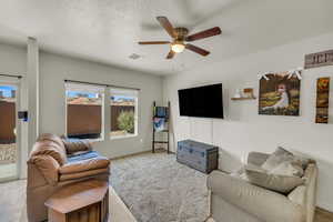 Living room with ceiling fan and a textured ceiling