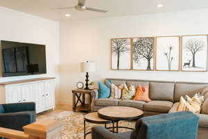 Living room with light hardwood / wood-style floors and ceiling fan