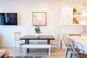 Dining space with sink and light wood-type flooring