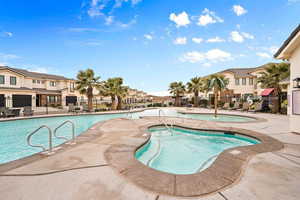 View of swimming pool featuring a community hot tub and a patio area