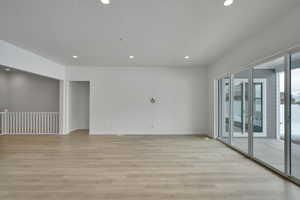 Empty room with a textured ceiling and light wood-type flooring