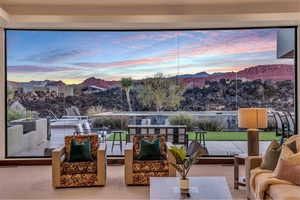 Patio terrace at dusk with outdoor lounge area and a mountain view