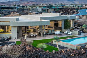 Back of house with a mountain view and a bar