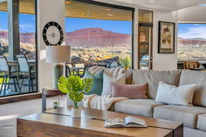 Living room featuring floor to ceiling windows, a mountain view, and carpet floors