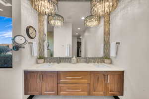 Bathroom featuring backsplash, vanity, and a notable chandelier