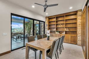 Carpeted dining space featuring ceiling fan