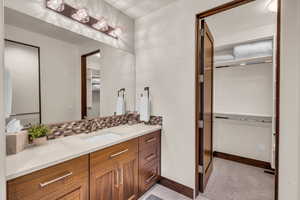 Bathroom featuring vanity and decorative backsplash