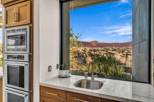 Kitchen with light stone countertops, appliances with stainless steel finishes, sink, and a mountain view