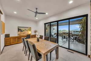 Dining room featuring light carpet and ceiling fan