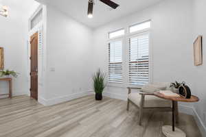 Living area with light hardwood / wood-style floors and ceiling fan