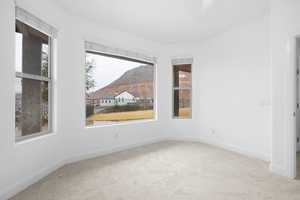 Spare room with a mountain view and carpet