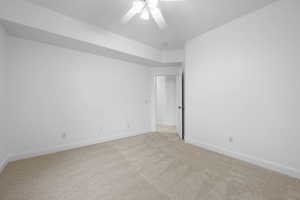 Carpeted empty room featuring ceiling fan