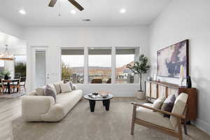 Living room featuring a mountain view, ceiling fan with notable chandelier, and light hardwood / wood-style floors