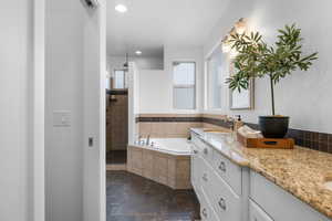 Bathroom featuring plus walk in shower and vanity