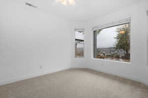 Carpeted empty room featuring ceiling fan