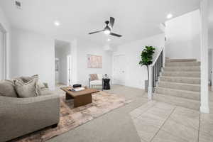 Carpeted living room with ceiling fan