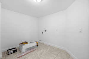 Laundry room with gas dryer hookup, hookup for an electric dryer, washer hookup, and light tile patterned floors