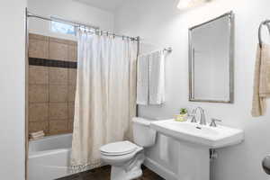 Bathroom with tile patterned flooring, shower / bath combination with curtain, and toilet