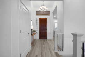 Entryway with an inviting chandelier and light hardwood / wood-style floors