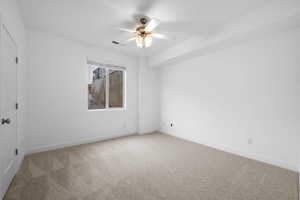 Unfurnished room featuring carpet and ceiling fan