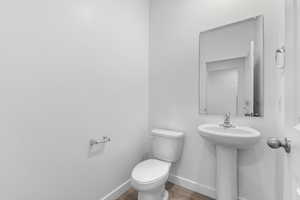 Bathroom with toilet and hardwood / wood-style floors