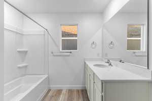 Bathroom featuring wood-type flooring, bathtub / shower combination, and vanity